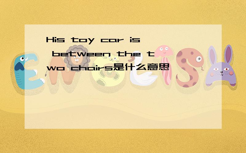 His toy car is between the two chairs是什么意思